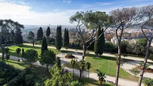 Villa Balestra ai Parioli, con pini e cipressi sui prati e la cupola di San Pietro all'orizzonte